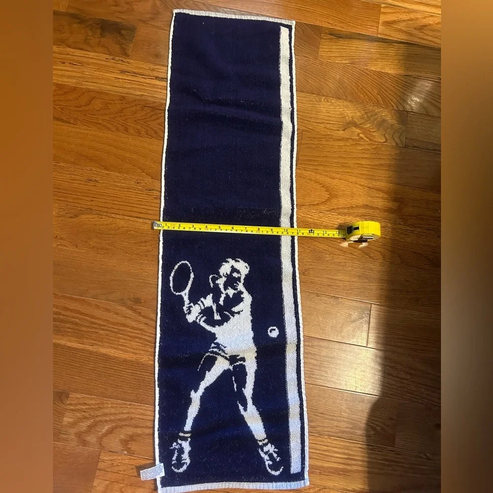 2 sports towels. 1 is reversible and has a tennis player. 1 is izod brand.